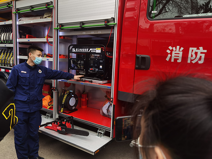 1616375009652550.jpg 消防队员为学生介绍消防车上的工具.jpg